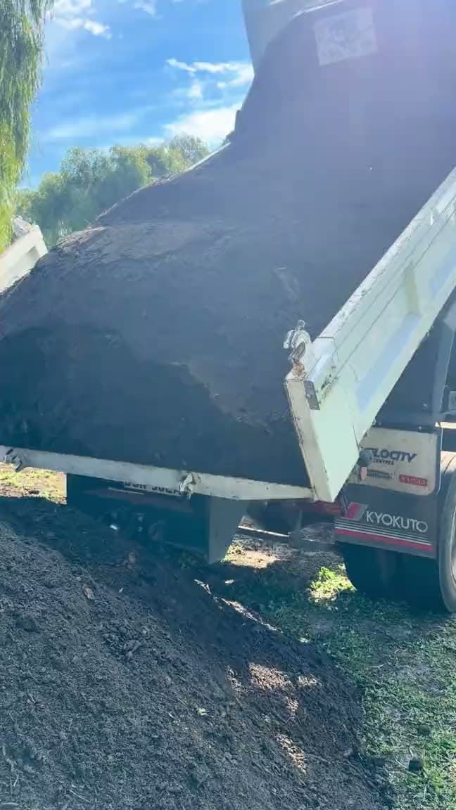 A WildSoil tipper truck delivering a load of compost on site