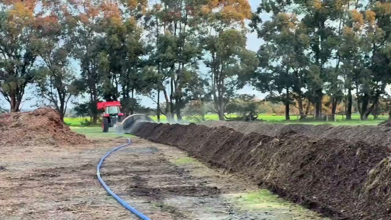 A tractor turning a steaming compost windrow at the WildSoil site in Busselton